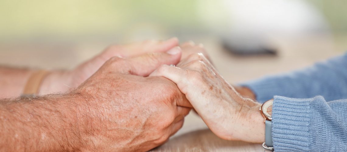 Senior couple holding hands for love, support and trust in retirement, counseling and marriage. Closeup elderly old people, hand holding and hope, empathy or respect, kindness and gratitude with care.